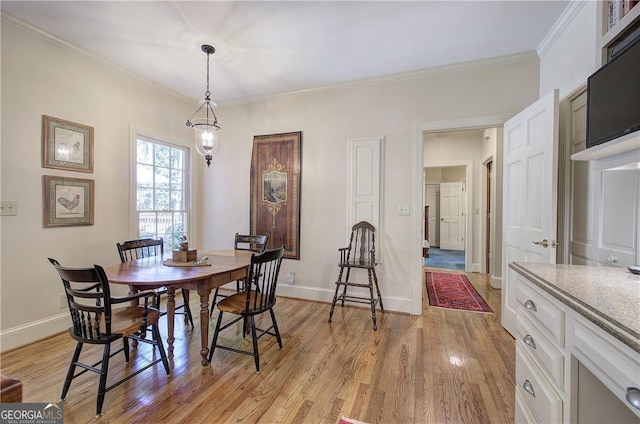 dining area featuring light hardwood / wood-style floors and ornamental molding