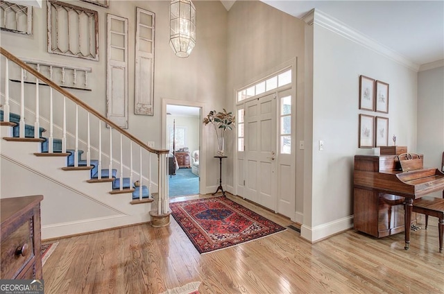 entrance foyer featuring ornamental molding, an inviting chandelier, and hardwood / wood-style floors