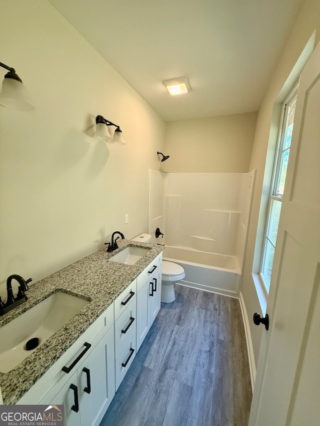 full bathroom with vanity, hardwood / wood-style flooring, toilet, and shower / bathtub combination