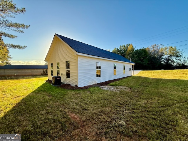 view of home's exterior with cooling unit and a lawn