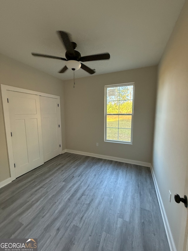 unfurnished bedroom with a closet, ceiling fan, and wood-type flooring