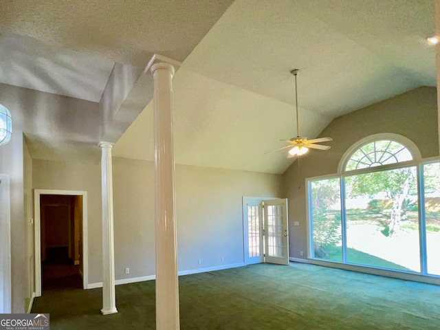 unfurnished living room featuring a textured ceiling, ornate columns, ceiling fan, lofted ceiling, and dark carpet