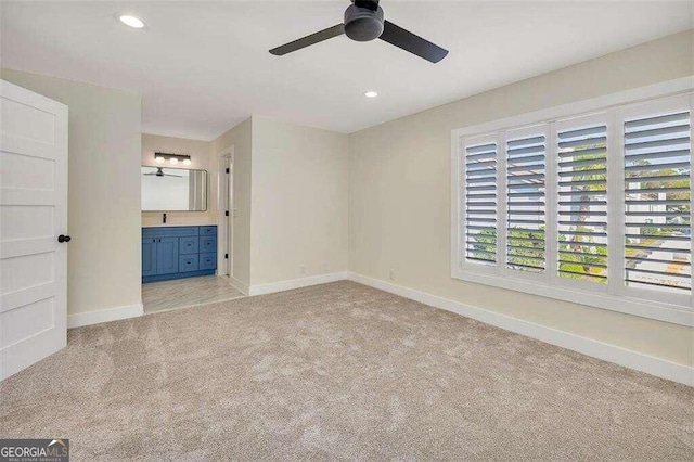 carpeted spare room featuring ceiling fan