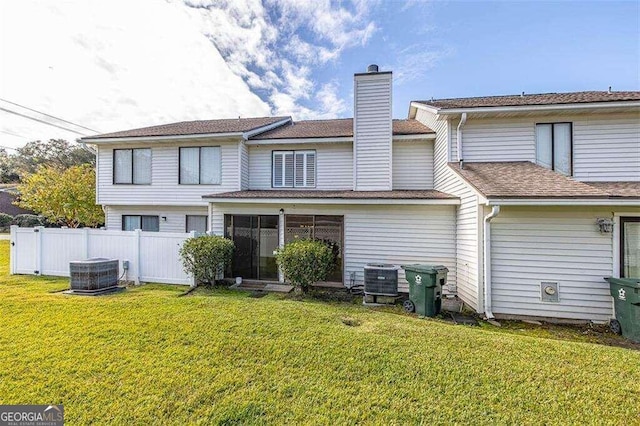 back of house with a lawn and central AC unit