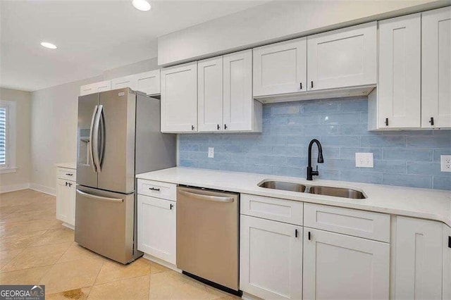 kitchen with white cabinets, light tile patterned floors, backsplash, sink, and stainless steel appliances