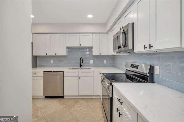 kitchen featuring white cabinets, light tile patterned floors, backsplash, sink, and stainless steel appliances