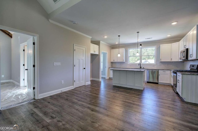 kitchen featuring stainless steel appliances, decorative light fixtures, white cabinets, ornamental molding, and dark hardwood / wood-style floors