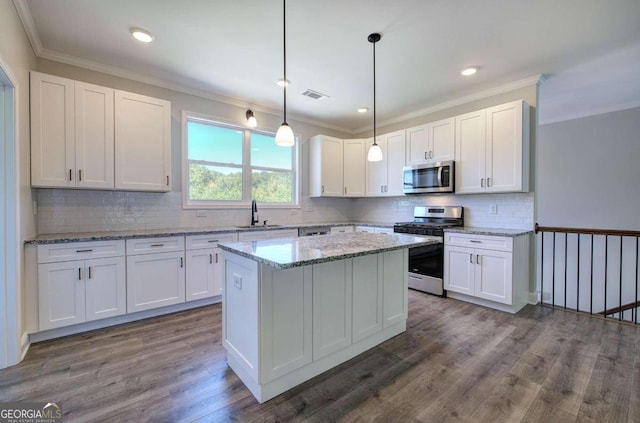 kitchen with white cabinets, hanging light fixtures, light stone counters, dark hardwood / wood-style floors, and stainless steel appliances