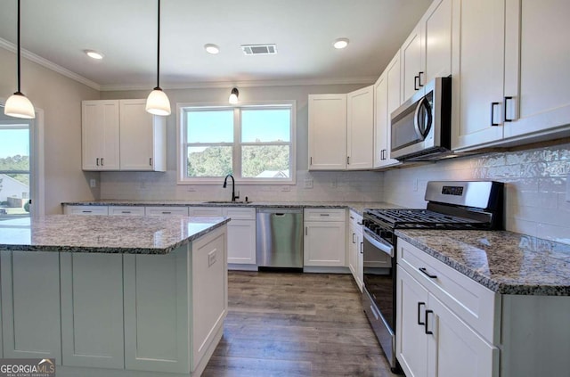 kitchen featuring appliances with stainless steel finishes, white cabinets, and plenty of natural light