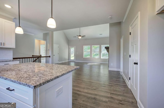 kitchen featuring dark hardwood / wood-style floors, backsplash, ornamental molding, pendant lighting, and white cabinets