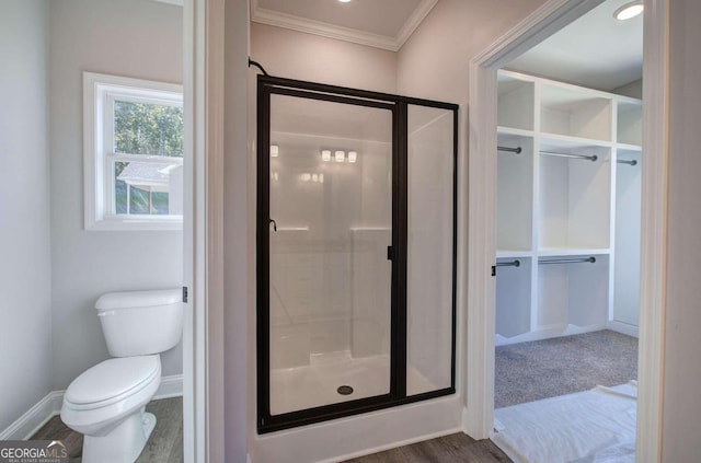 bathroom featuring ornamental molding, hardwood / wood-style flooring, toilet, and an enclosed shower