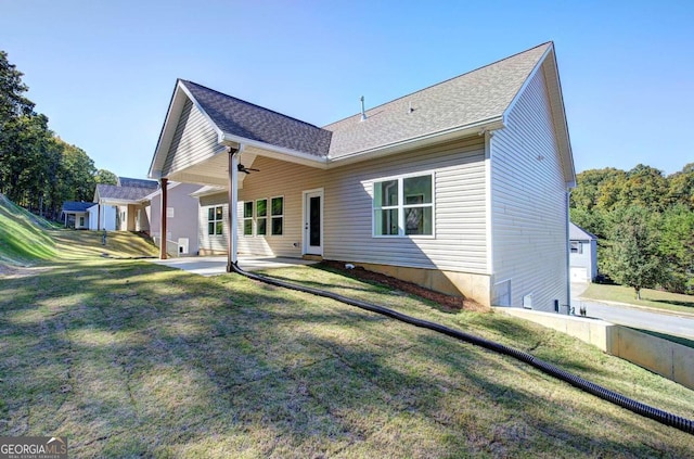 back of house with a patio and a lawn