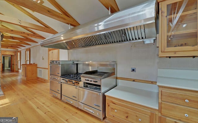 kitchen with island range hood, vaulted ceiling, and light wood-type flooring