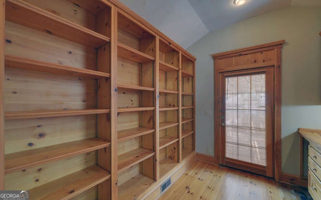 doorway to outside featuring light hardwood / wood-style flooring and lofted ceiling