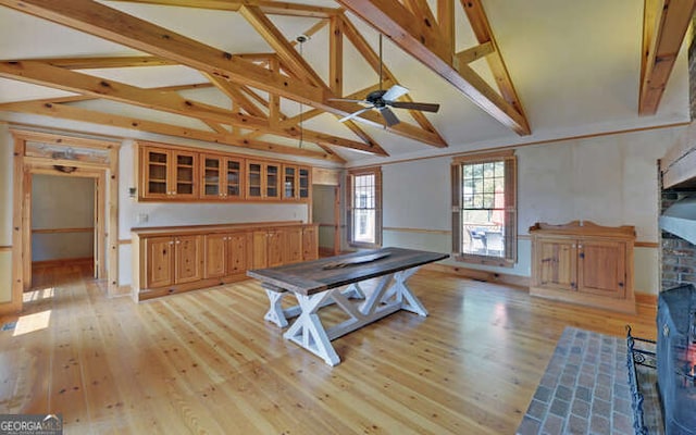 interior space featuring light hardwood / wood-style flooring, vaulted ceiling with beams, and ceiling fan