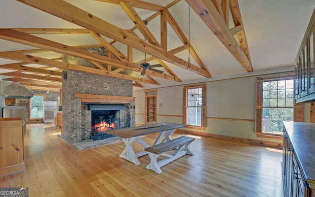 living room featuring lofted ceiling with beams and light wood-type flooring