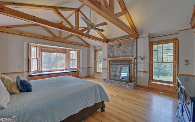 bedroom featuring vaulted ceiling with beams, multiple windows, and wood-type flooring