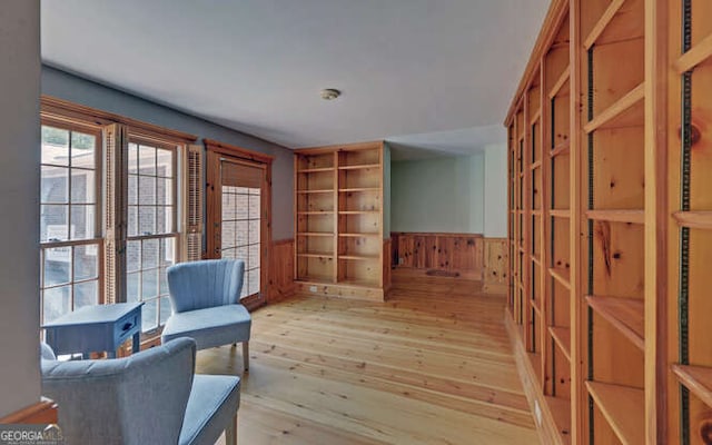 sitting room featuring light hardwood / wood-style floors and wood walls