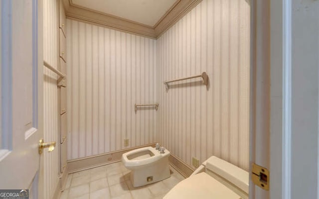 bathroom with toilet, crown molding, and a bidet