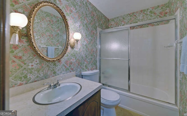 full bathroom featuring toilet, vanity, and shower / bath combination with glass door