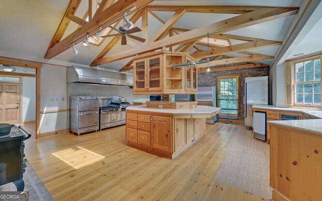 kitchen with a center island, light wood-type flooring, lofted ceiling with beams, and ceiling fan