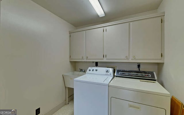 clothes washing area with sink, independent washer and dryer, and cabinets