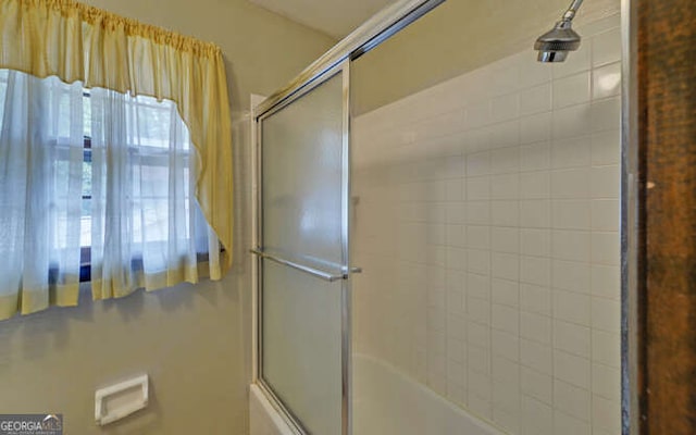 bathroom with shower / bath combination with glass door