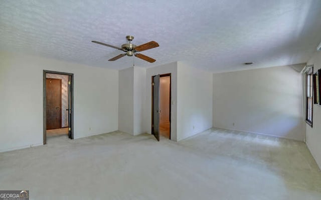 carpeted spare room with a textured ceiling and ceiling fan