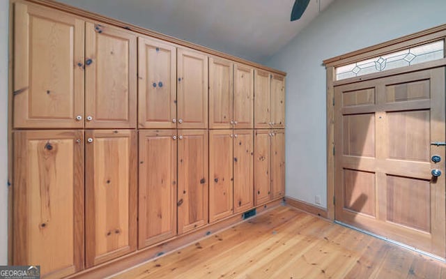 foyer with ceiling fan, light wood-type flooring, and vaulted ceiling