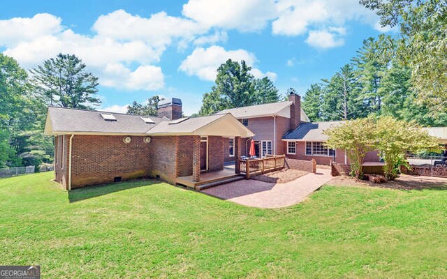 rear view of house featuring a yard and a patio