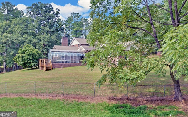 view of yard featuring a sunroom and a rural view