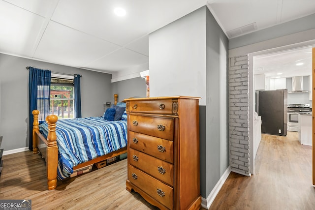 bedroom featuring stainless steel fridge and light wood-type flooring