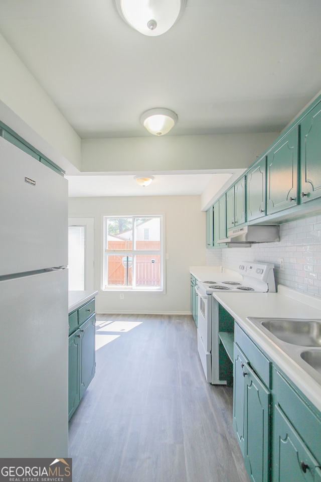 kitchen featuring white appliances, decorative backsplash, and light hardwood / wood-style flooring