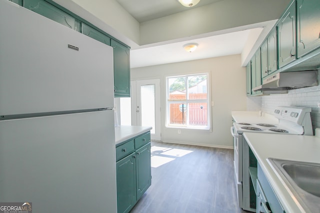 kitchen featuring white appliances, sink, green cabinets, decorative backsplash, and light hardwood / wood-style flooring