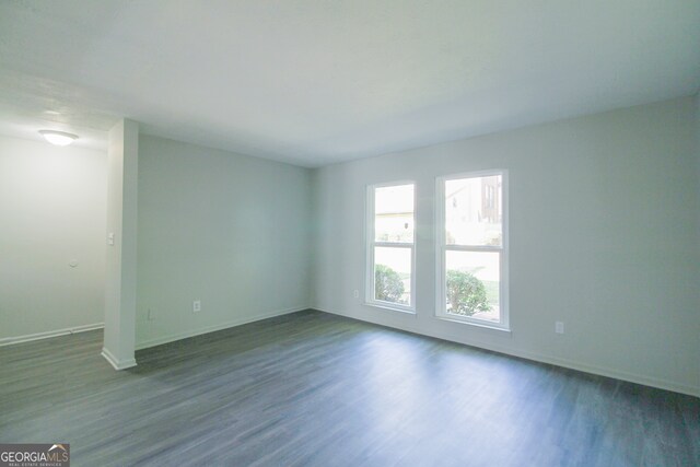 unfurnished room with dark hardwood / wood-style floors