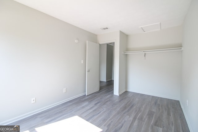 unfurnished bedroom featuring wood-type flooring and a closet