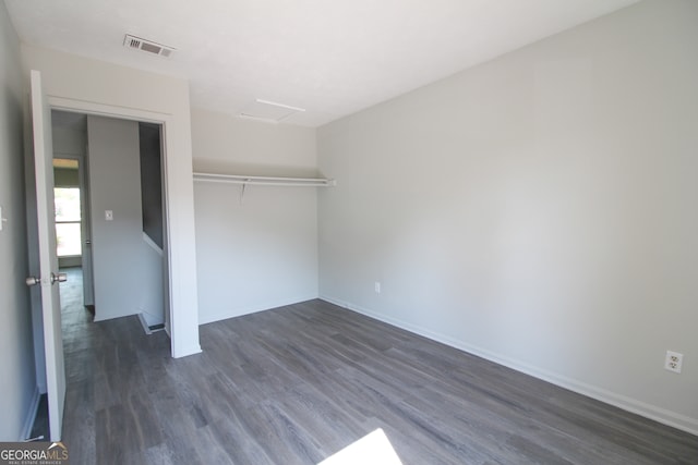 unfurnished bedroom featuring a closet and dark hardwood / wood-style flooring