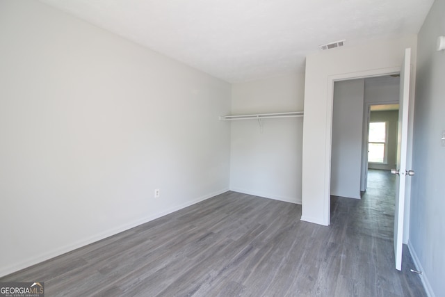 unfurnished bedroom featuring dark hardwood / wood-style floors and a closet