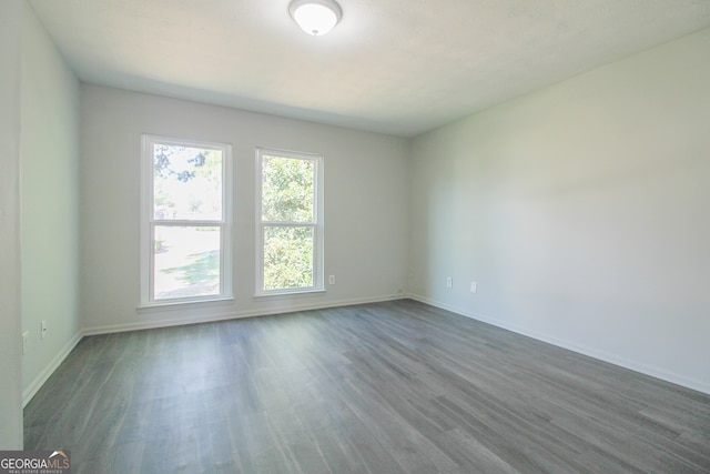 empty room with dark hardwood / wood-style flooring