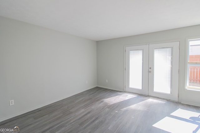 empty room with french doors and dark wood-type flooring