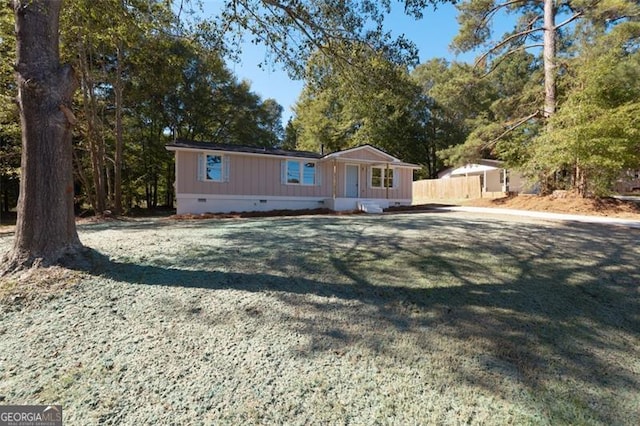 manufactured / mobile home featuring a front yard, crawl space, and fence