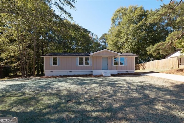 manufactured / mobile home featuring fence, a front yard, and crawl space
