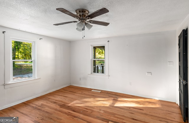 spare room with light hardwood / wood-style flooring, a textured ceiling, and ceiling fan