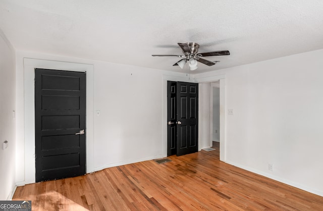 spare room featuring ceiling fan, a textured ceiling, and hardwood / wood-style floors