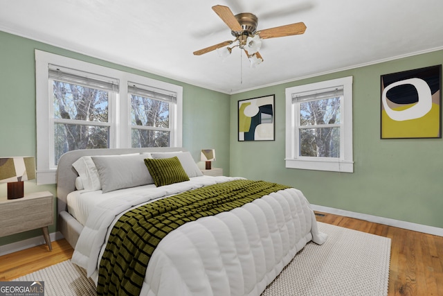 bedroom featuring crown molding, hardwood / wood-style flooring, and ceiling fan