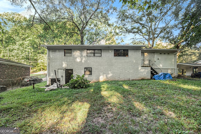 rear view of property with a lawn