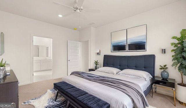 bedroom with ceiling fan, ensuite bathroom, and light carpet