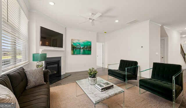 living room with hardwood / wood-style flooring, ceiling fan, and crown molding