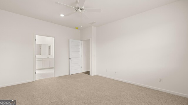unfurnished bedroom featuring connected bathroom, ceiling fan, and light colored carpet