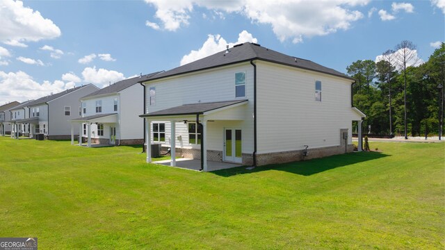 back of house with central air condition unit, a patio, a yard, and french doors